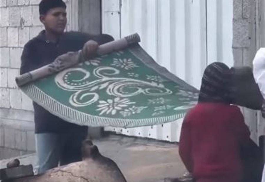 أثناء إعدادها للخبز... أطفالٌ في غزة يحمون والدتهم بِـ"الحصير"! (فيديو)