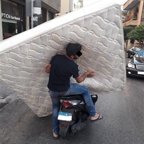 بالصورة: عجائب دنيا السير... مواطن يحمل فراشاً على متن دراجة